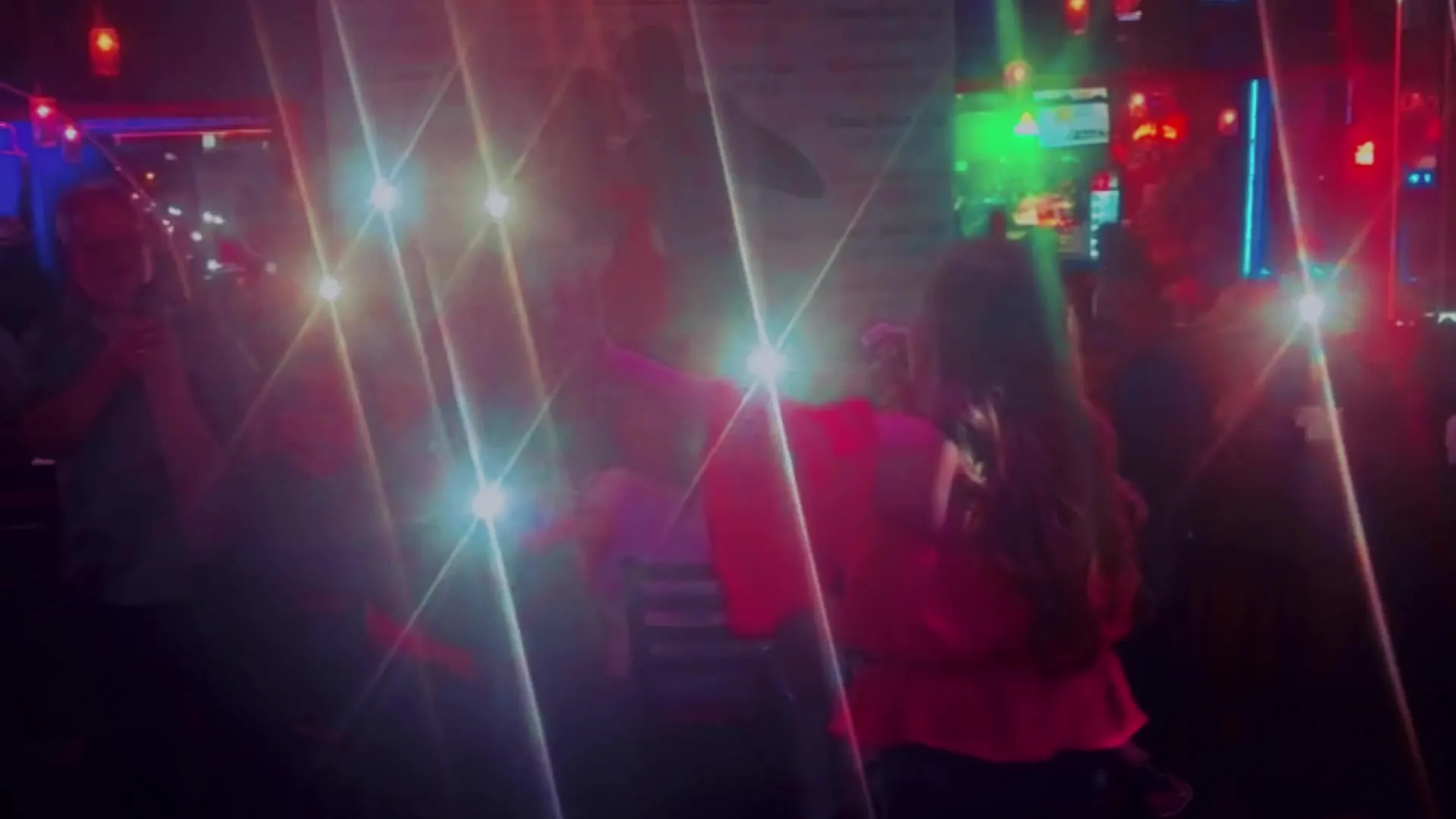 Party guests dancing under red and white lights